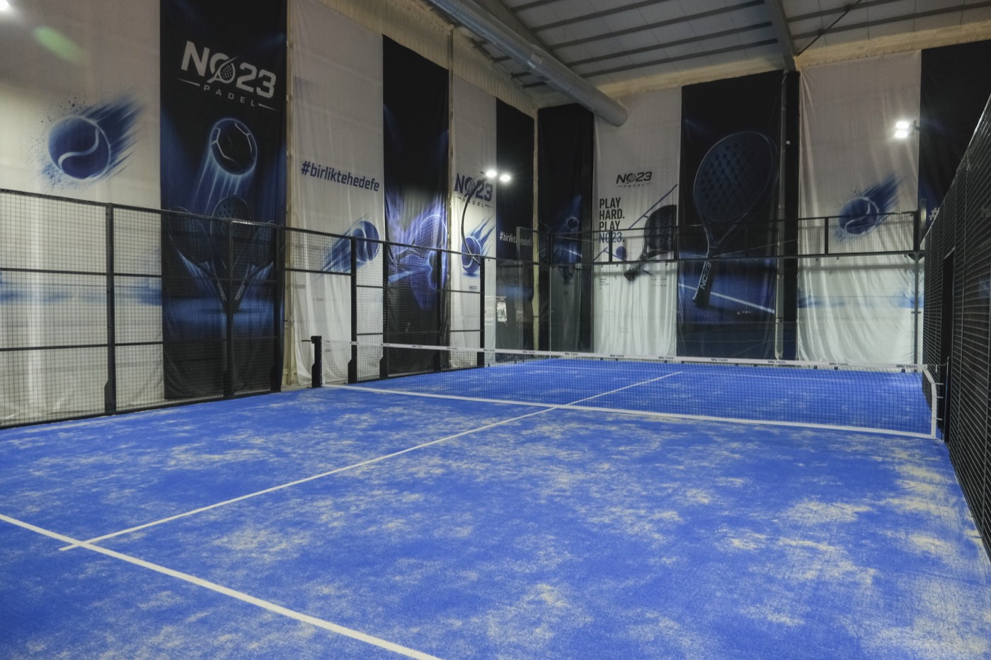 No23 Padel kapalı cam kortu — file ve markalı bannerlar